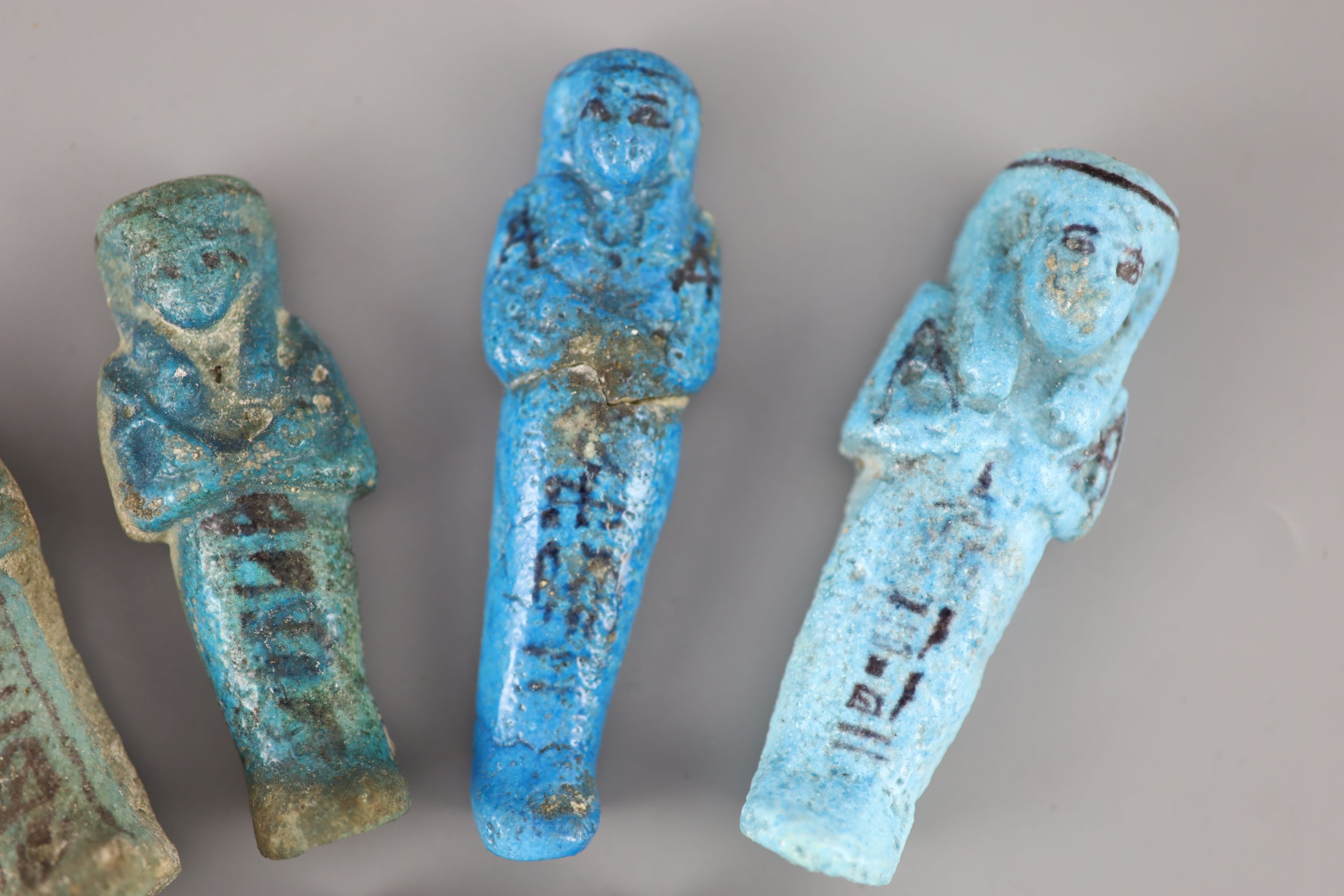 Five Egyptian turquoise glazed faience shabti and three fragments, New Kingdom to late period, Provenance - A. T. Arber-Cooke